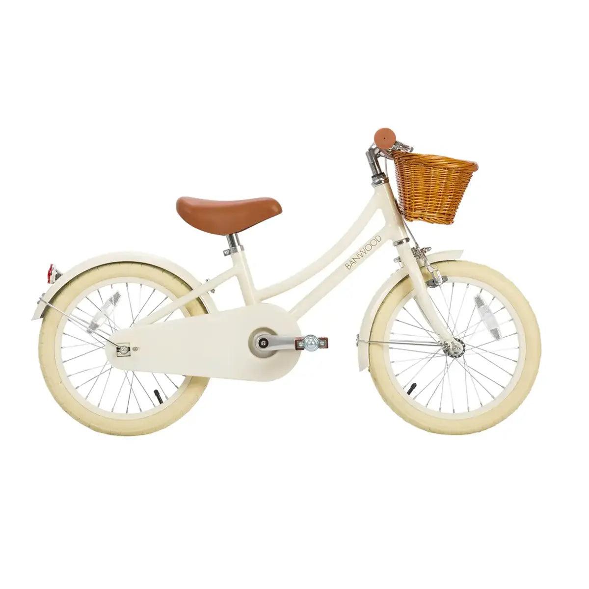Cream children's bicycle with a brown basket and seat on a white background