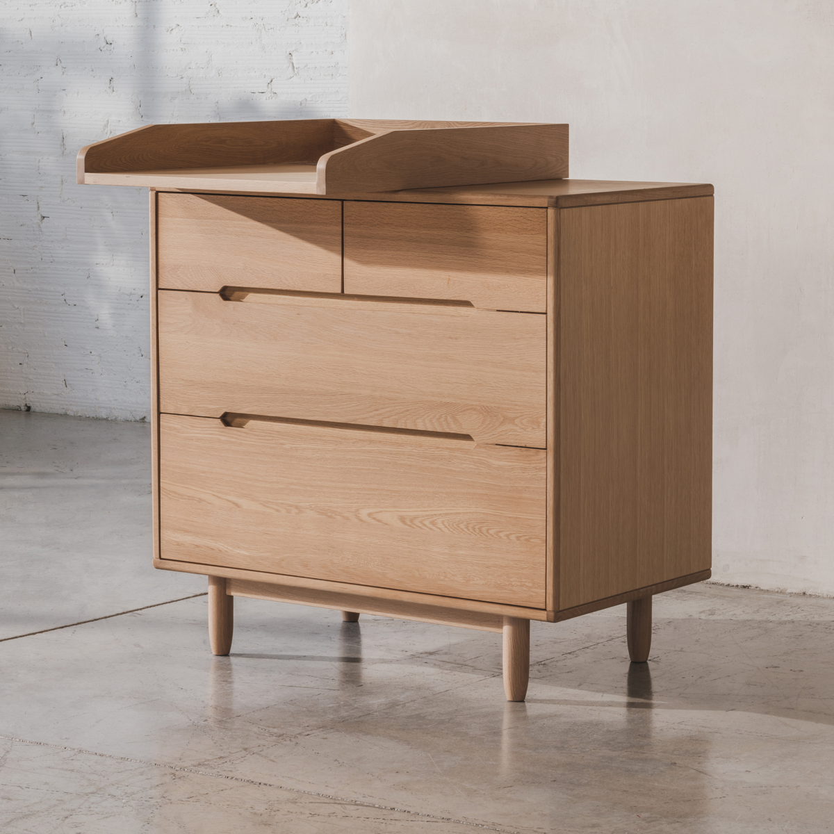 Wooden dresser with two drawers on a light gray floor and white wall background